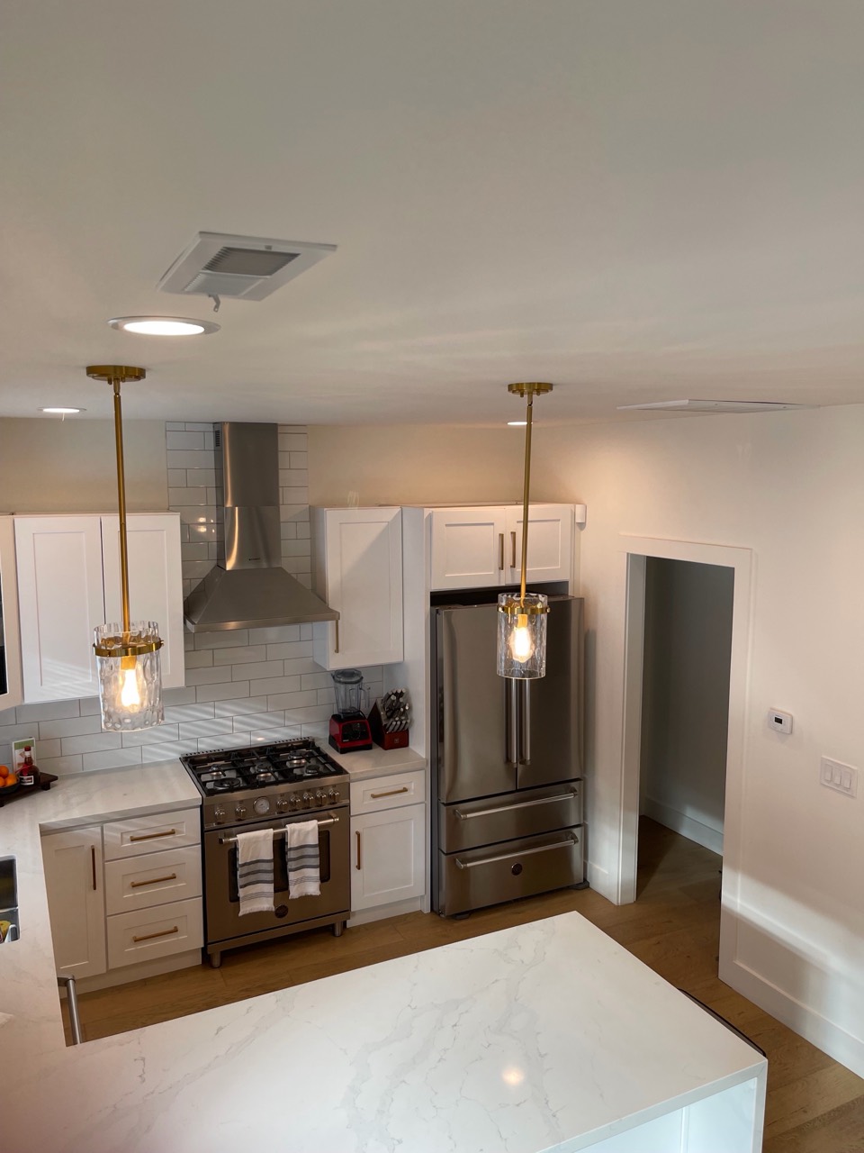Bright kitchen with white cabinets, stainless steel appliances, and a marble island